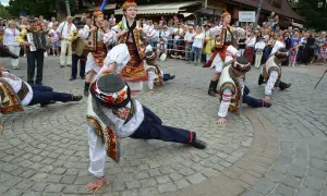 Tancerze w barwnych strojach ludowych wykonują akrobacje podczas międzynarodowego festiwalu folkloru ziem górskich.