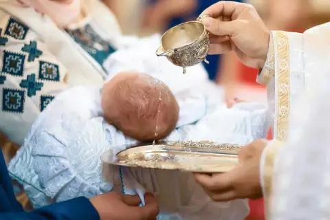Chrzest święty to początek nowej drogi. Woda obmywa niemowlę, symbolizując oczyszczenie i dar łaski.