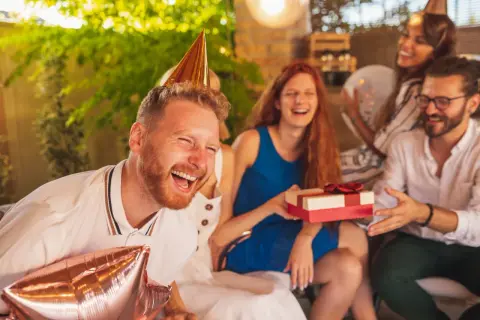 Impreza urodzinowa w pełni! Wesołe twarze, prezent i balony. Idealne krótkie życzenia urodzinowe - śmieszne, bo radość jest najważniejsza!