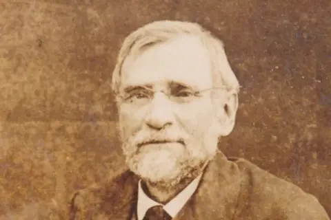 Oskar Kolberg, najsłynniejszy polski etnograf, z siwą brodą i okularami, wpatruje się w dal.