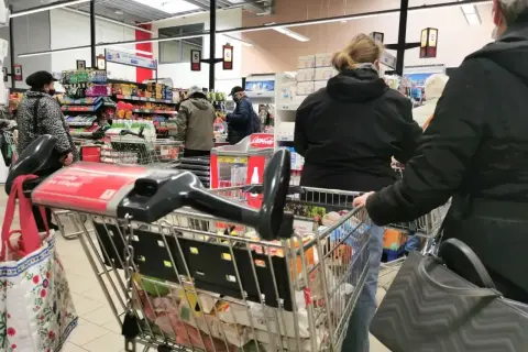 Ludzie robią zakupy w supermarkecie. Czy to wielka sobota czy to święto, kolejki do kas są długie.