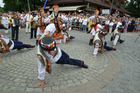 Tancerze w barwnych strojach ludowych wykonują akrobacje podczas międzynarodowego festiwalu folkloru ziem górskich.