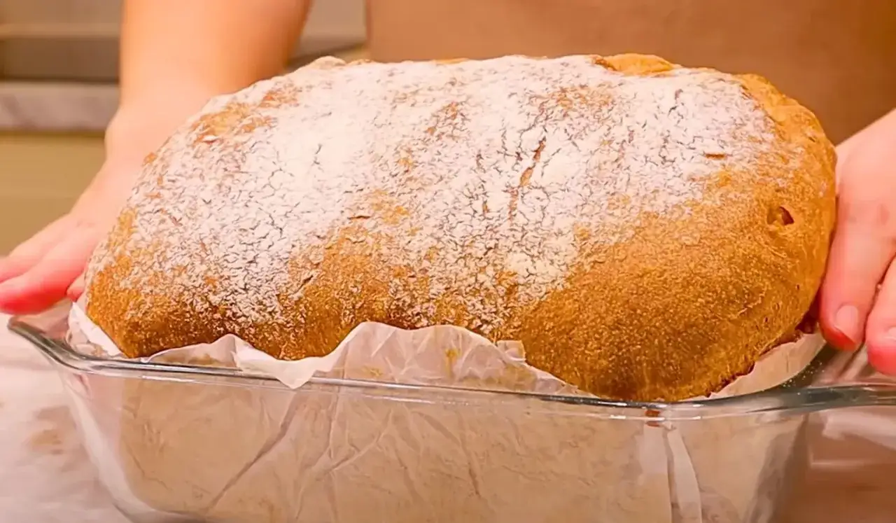 Świeżo upieczony chleb, posypany mąką, w szklanej formie. Idealny na dzień chleba!